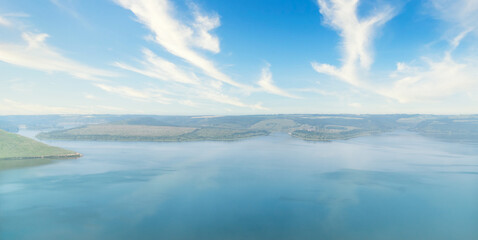 Serene lake view with clear blue skies and fluffy clouds. Beauty of nature. Copy space background.