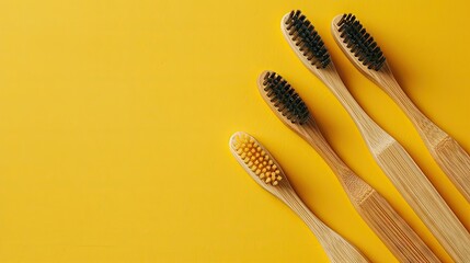 Dental care essentials: Flat lay of toothbrushes with bamboo handles on a yellow surface. Eco-friendly concept with ample copy space