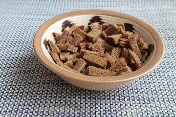 Crackers from dark bread in a ceramic bowl. Ceramic bowl with crackers.