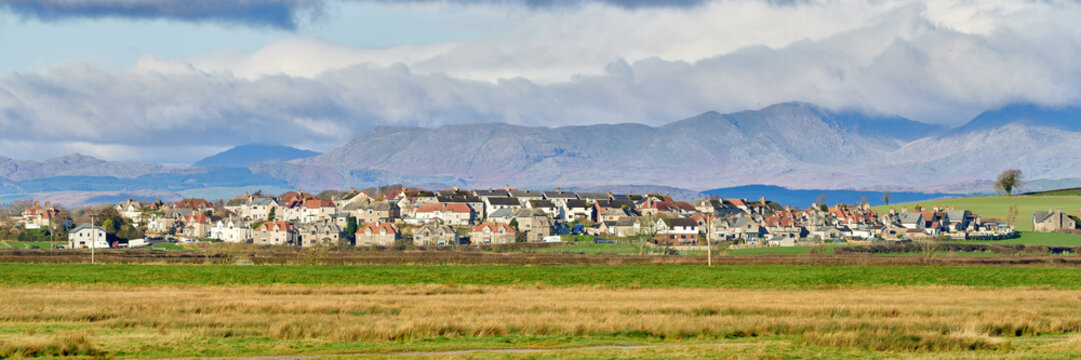 Panorama of Ravenstown, on the Cartmel Peninsula with the lake district fells in the distance.