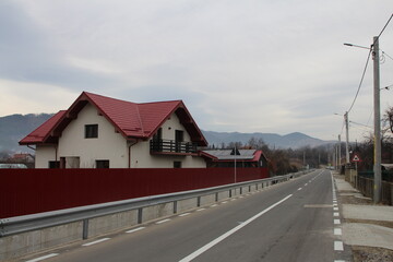A road with a building and mountains in the background