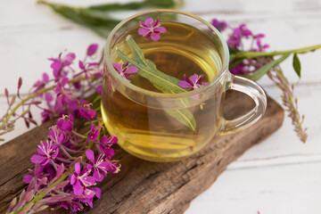 A drink (decoction) from the leaves and flowers of the medicinal plant ivan-tea (cypress, epilobium) in a mug. Traditional medicine, collection of useful herbs. Alternative medicine