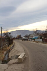 A road with houses and mountains in the background
