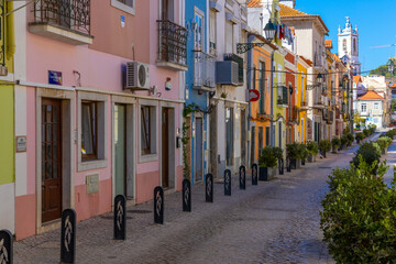 Setubal, Portugal. 16 August 2023. Colorful old houses in a European street, narrow with its ancient buildings, European city. A cityscape of Setúbal with a white church in the distance.