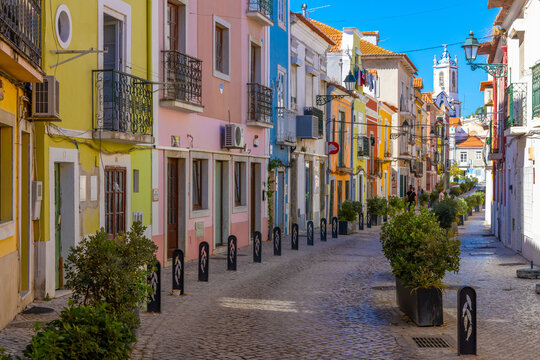 Setubal, Portugal. 16 August 2023. Colorful old houses in a European street, narrow with its ancient buildings, European city. A cityscape of Setúbal with a white church in the distance.