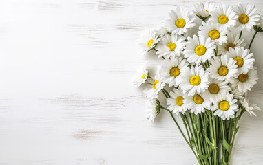 a bouquet of garden camomile flowers on a white wooden table.