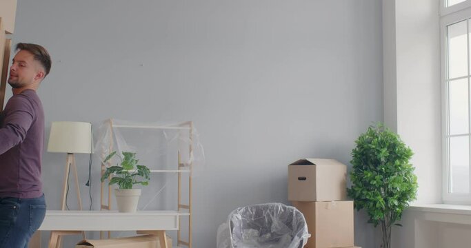 Man, unprofessional mover carrying cardboard box heavy stack, falling moving new apartment, unhappy homebuyer transporting boxes, organizing new home move, changing residence, adult life beginning