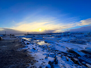 Icebergs swimming at the famous glacier lagoon around Vatnajokull National Park during winter around sunset time 