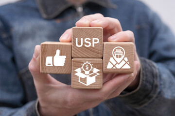 Man holding wooden cubes sees abbreviation: USP. Unique Selling Point ( USP ) business concept. Competitive advantage of product and service and attract customers.