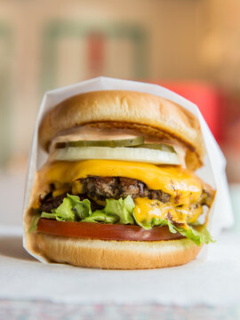 Beef cheeseburger with wrapper.