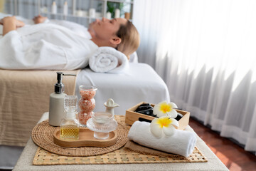 Fototapeta na wymiar Aromatherapy massage on daylight ambiance or spa salon composition setup with focus decor and spa accessories on blur woman enjoying blissful aroma spa massage in resort or hotel background. Quiescent
