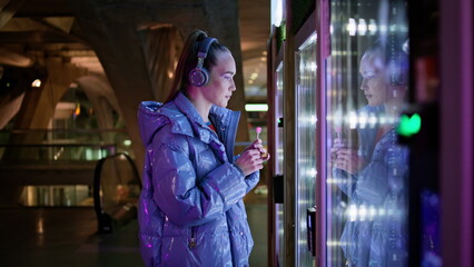 Woman choosing food automat standing in subway close up. Girl buying snacks.