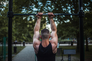 Naklejka premium Training in the park, on the street.Athlete in training, rear view. Trained athlete's hands. Biceps