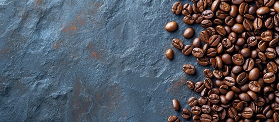Top view of roasted coffee beans on a stone background, providing space for your text.