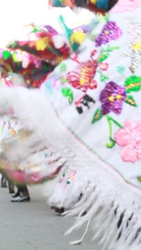 vertical video, group of mexican dancers wearing beautiful shinny handmade capes and plume. Mexican carnival in Tlaxcala