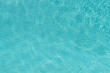 Clear water surface in a pool, ripple water in tiled swimming pool with sun reflection
