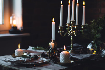Beautiful table setting for family Christmas dinner at home. Cozy atmosphere, candlelight. Wine...
