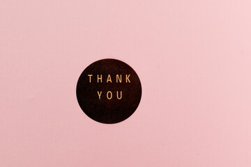 The inscription Thank you in a circle on a pink background, background with the inscription Thank...
