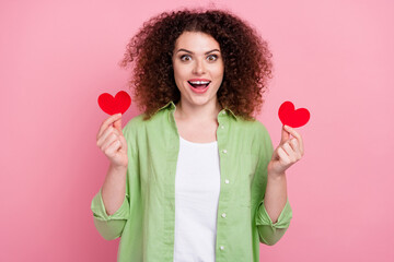 Photo portrait of attractive young woman hold excited two heart postcards wear trendy green clothes...