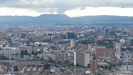 Fototapeta na wymiar Aerial view to the north, urban landscape full of tall buildings surrounded by mountains in Bogotá, Colombia.