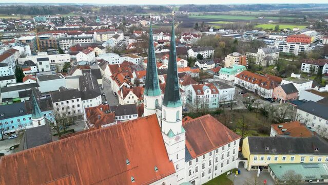 Drone flight through church towers of Stiftskirche at Kapellplatz in Altoetting