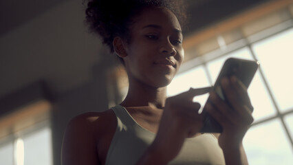 black woman using mobile phone in fitness