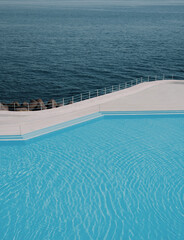 Swimming pool by the ocean, minimalist aesthetic summer and vacation background, blue palette, copy space