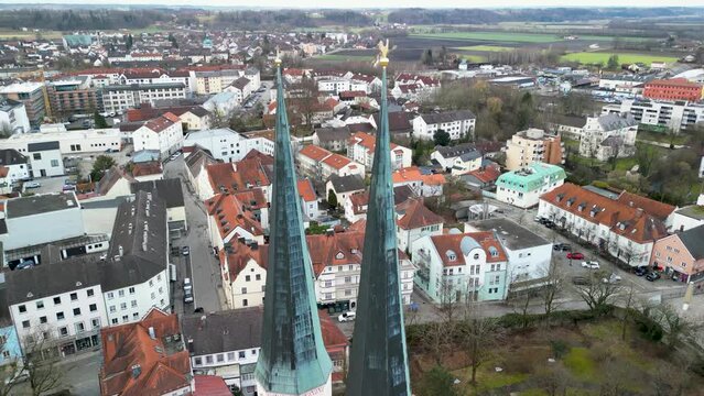 Backwards flight from church towers of Stiftskirche revealing Kapellplatz in Altoetting