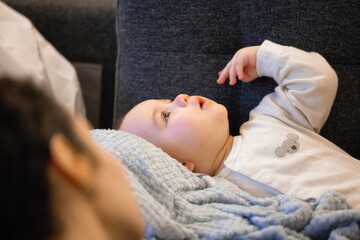 Happy baby boy playing on a couch at home