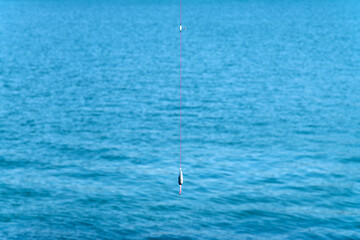 View of a fishing string against the blue sea