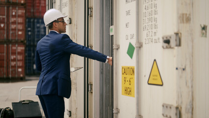 businessman inspects a container at the port.