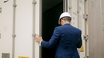 businessman inspects a container at the port.