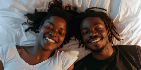 Two people are lying down and smiling. A relaxed and happy couple experiencing a moment of joy and pleasure