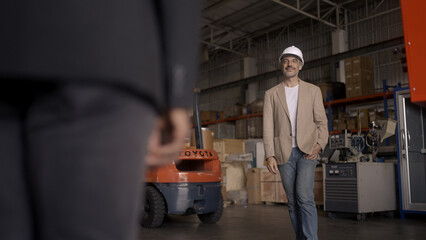 Businessman checking warehouse with staff