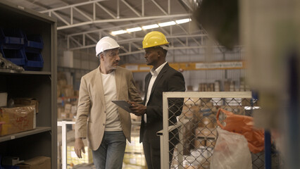 Businessman checking warehouse with staff - 732092572