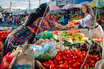 Indigenous seller from a market in Quetzaltenango serves her client.