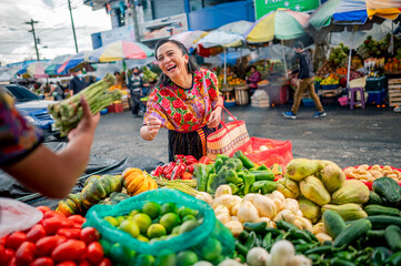 Beautiful Latina shopper enjoys shopping at the vegetable market.