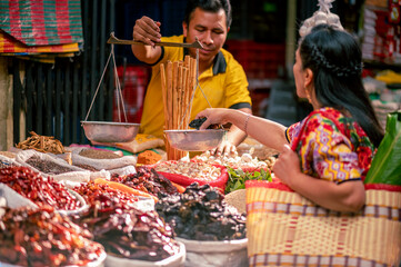 Portrait of a woman in a local store buying and a man weighing merchandise.