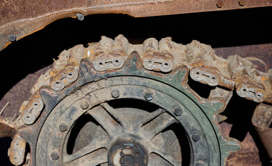 Fragment of a rusty caterpillar and wheel of a tank