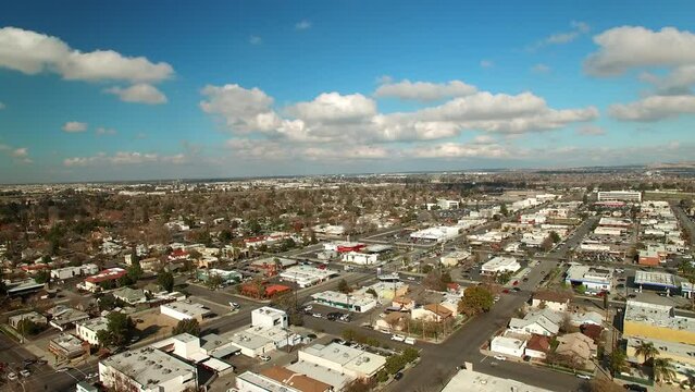 Aerial Backward Shot Of Residential Houses In City Under Clouds On Sunny Day - Bakersfield, California