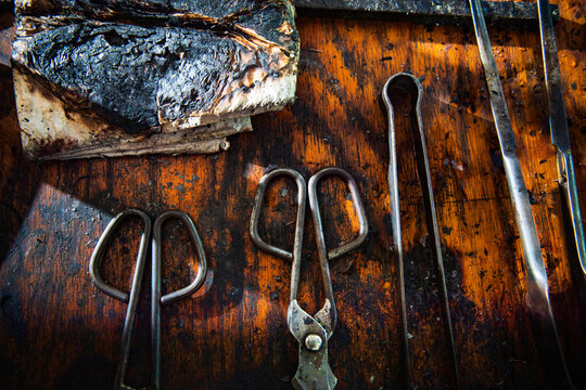 Metal tools at a glass blower's rustic wooden bench