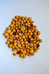 Soybean falling on a pile of soybeans on white background