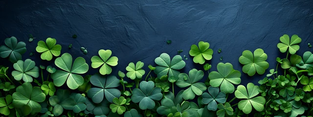 Foto op Canvas Border made of clover leaves on dark blue background with copy space. Four leaved shamrocks. St Patrick Day holiday symbol. Template for design card, invitation, banner © ratatosk