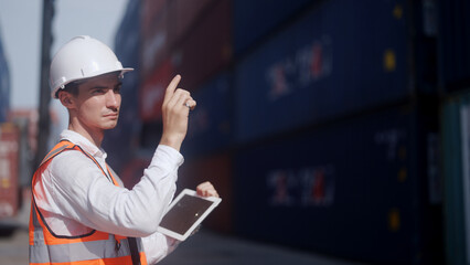 Warehouse worker using digital tablet while looking at warehouse dock