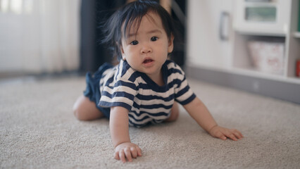 Baby girl crawling on floor at home