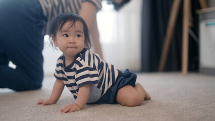 Baby girl crawling on floor at home