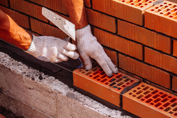 Builder laying bricks on construction site