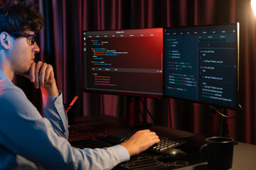 Working IT developer concentrating online software development information on surrounded by coding...
