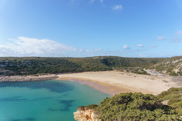 View over the beach of Praia do Barranco with clear turquoise water and a blue sky, Sagres,...