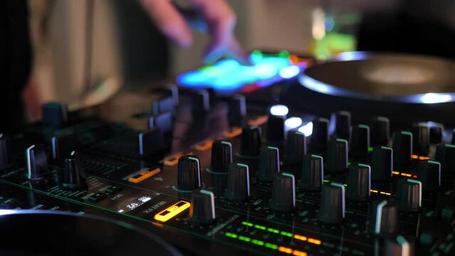 DJ hands touching buttons and sliders while playing electronic music.DJ console